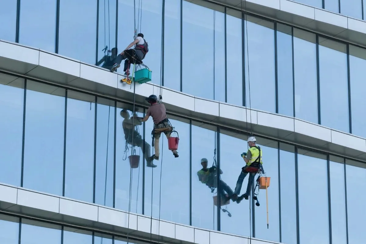 Traditional rope access — workers suspended on building facade